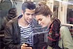 Couple on subway looking at smartphone together