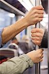 Subway commuters holding onto grab handle