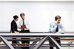 Businessman talking on cell phone, colleagues using digital tablet nearby