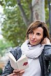 Woman reading paperback book outdoors