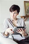 Woman using digital tablet at home