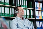 Young man portrait sitting office headset smiling