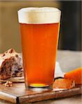 Glass of Beer with Bread and Cheese on Breadboard, Studio Shot