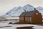 Wooden buildings with snowy mountains behind, Ny Alesund, Spitsbergen (Svalbard), Arctic, Norway, Scandinavia, Europe