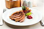 Roasted filet of duck breast served with salad and cranberry sauce