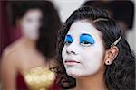 Serious young female cirque performer with white facepaint