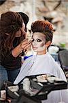 Aesthetician working on circus actress eyeliner outdoors