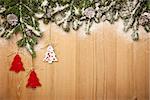 Christmas background with fresh firtree, decorative handmade trees and cones on wood with bright snow