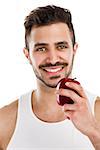 Athletic young man holding a fresh apple, isolated over a white background