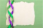 Holidays card. Old paper with ribbons on green cardboard background. Stock photo