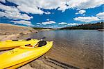 Pair of Yellow Kayaks on a Beautiful Mountain Lake Shore.