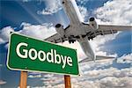 Goodbye Green Road Sign and Airplane Above with Dramatic Blue Sky and Clouds.