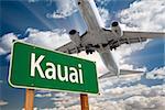 Kauai Green Road Sign and Airplane Above with Dramatic Blue Sky and Clouds.