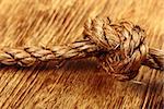 Close up of rope knot on wooden background