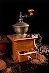 Coffee still life. Coffee grinder, ground coffee and coffee beans isolated on black background. Luxurious vintage coffee background.