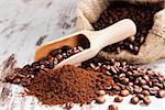 Traditional coffee background. Ground coffee and coffee beans on white wooden textured background. Culinary aromatic coffee drinking.