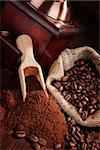 Coffee beans, ground coffee, vintage coffee mill and sack with coffee beans on brown wooden background. Culinary coffee background.