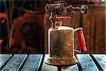 Closeup image of an antiuqe bronze kerosene torch in an abandoned shop in Iceland