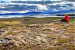 A woman admiring the view from the top of Helgafell Mountain in western Iceland