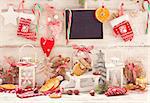 Christmas decorations with cookies in a glass bell jar on a sledge with place for greeting on chalk blackboard. Toned photo.