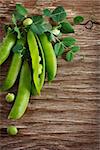 Fresh green peas on an old wooden background with copy space.