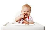 Little baby sitting at the table and laughs. Isolated on white background.