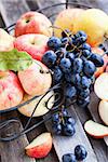 Fresh red apples and dark grape on the wooden table