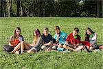 Teens with headphones and textbooks studying outdoors