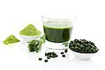 Green food supplement. Spirulina, chlorella and wheatgrass. Green juice, green pills, wheatgrass blades and ground powder isolated on white background. Healthy lifestyle.
