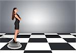 Beautiful businesswoman standing with crossed arms. Floor with checkerboard texture and gray wall