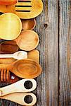 Border of Various Wooden Spoons and Cooking Utensils isolated on Rustic Wooden background