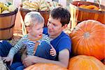 happy family of two having fun at pumpkin patch