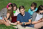 Group of cheerful students texting and studying