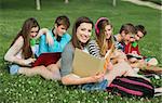 Smiling student with binder and group of friends outdoors