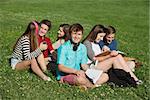 Group of six white teenagers doing homework outdoors