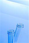 empty test tubes in laboratory on table and blue light tint background