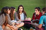 Shocked female teenage student sitting with friends