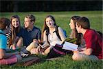 Smiling young female student sitting with cheerful friends