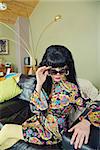 Groovy woman in 1960s fashion looking over sunglasses