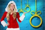 Pretty girl presenting in santa outfit against blurred christmas background