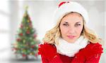 Happy festive blonde  against blurry christmas tree in room