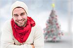 Handsome hipster against blurry christmas tree in room