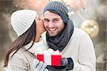 Winter couple holding gift against blurred christmas background