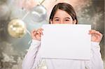 Cute little girl showing card against blurred christmas background