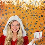 Pretty girl in santa outfit holding gift against yellow vignette