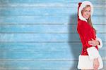 Festive blonde smiling at camera against blurred wooden planks