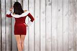 Rear view of sexy santa girl against blurred wooden planks