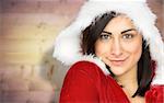 Pretty girl smiling in santa outfit  against blurred wooden planks