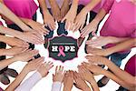 Hands joined in circle wearing pink for breast cancer against breast cancer awareness message