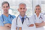 Group of doctor and nurses standing together against breast cancer awareness ribbon